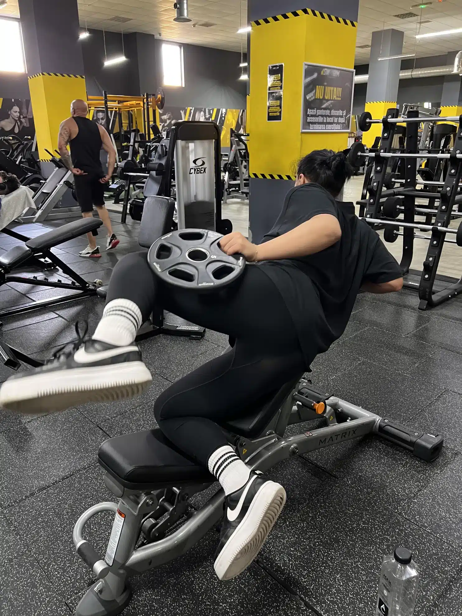 antrenor personal de fitness asista elev la raw machine ridicari de picioare in lateral de pe banca inclinata pentru fesieri